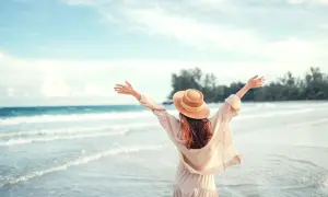 Kobieta w kapeluszu cieszy się plażą, szukając atrakcji dla dzieci pomorskie.