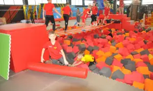 Dzieci bawią się w basenie z gąbkami w parku trampolin. To świetne kielce atrakcje dla dzieci, pełne radości i ruchu.