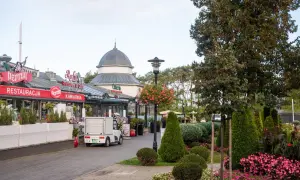 Ulica w Międzyzdrojach z restauracjami i kawiarniami, zielenią i ozdobnymi krzewami. Idealne miejsce na spacer i odkrywanie międzyzdrojskich atrakcji.