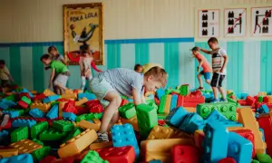 Dzieci budują wesołe konstrukcje z wielkich klocków w kolorowym parku rozrywki dla małych dzieci.