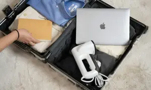 Pakowanie bagażu rejestrowanego: laptop, parownica do ubrań i książka. Elektronika w bagażu rejestrowanym to wygoda w podróży.