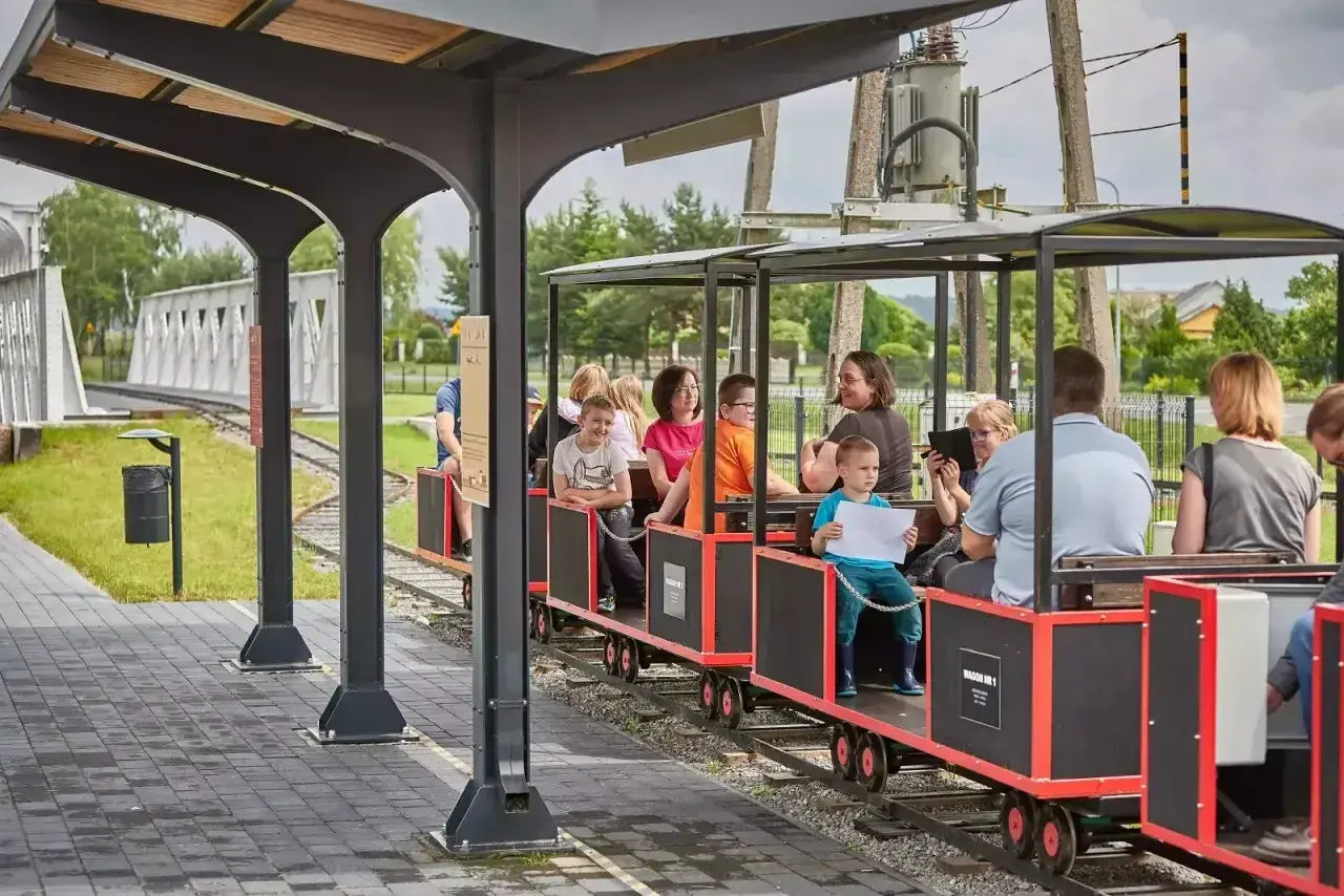 Rodzinny przejazd kolejką wąskotorową to świetne zwierzyniec atrakcje dla dzieci. Uśmiechnięte twarze i radosne okrzyki świadczą o udanej zabawie.
