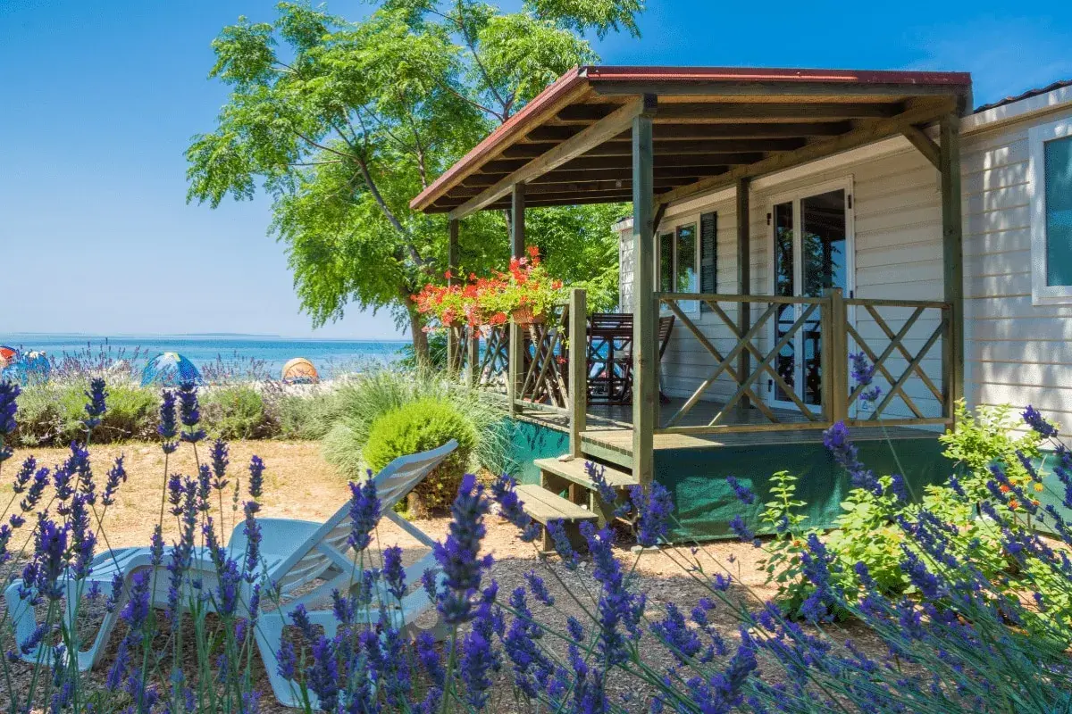 Idealne miejsce, gdzie na wakacje z dziećmi: domek przy plaży, leżaki i lawenda.