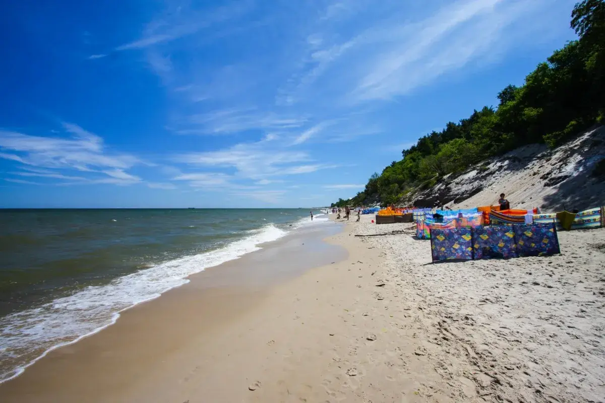 Słoneczna plaża w Chłapowie z kolorowymi parawanami, idealna na rodzinne wakacje. Atrakcje dla dzieci czekają!