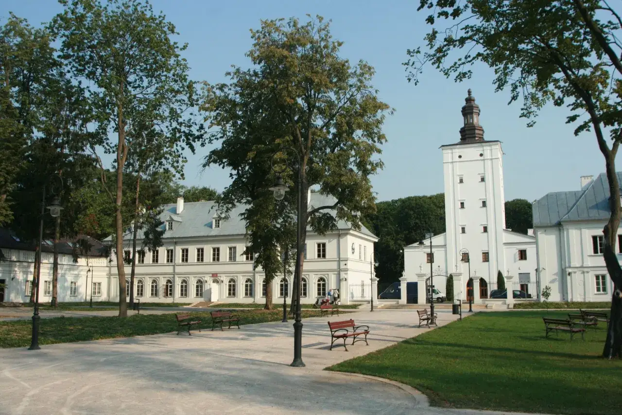Biała Podlaska oferuje atrakcje dla dzieci: park z ławkami i zabytkowe budynki, w tym wieża.