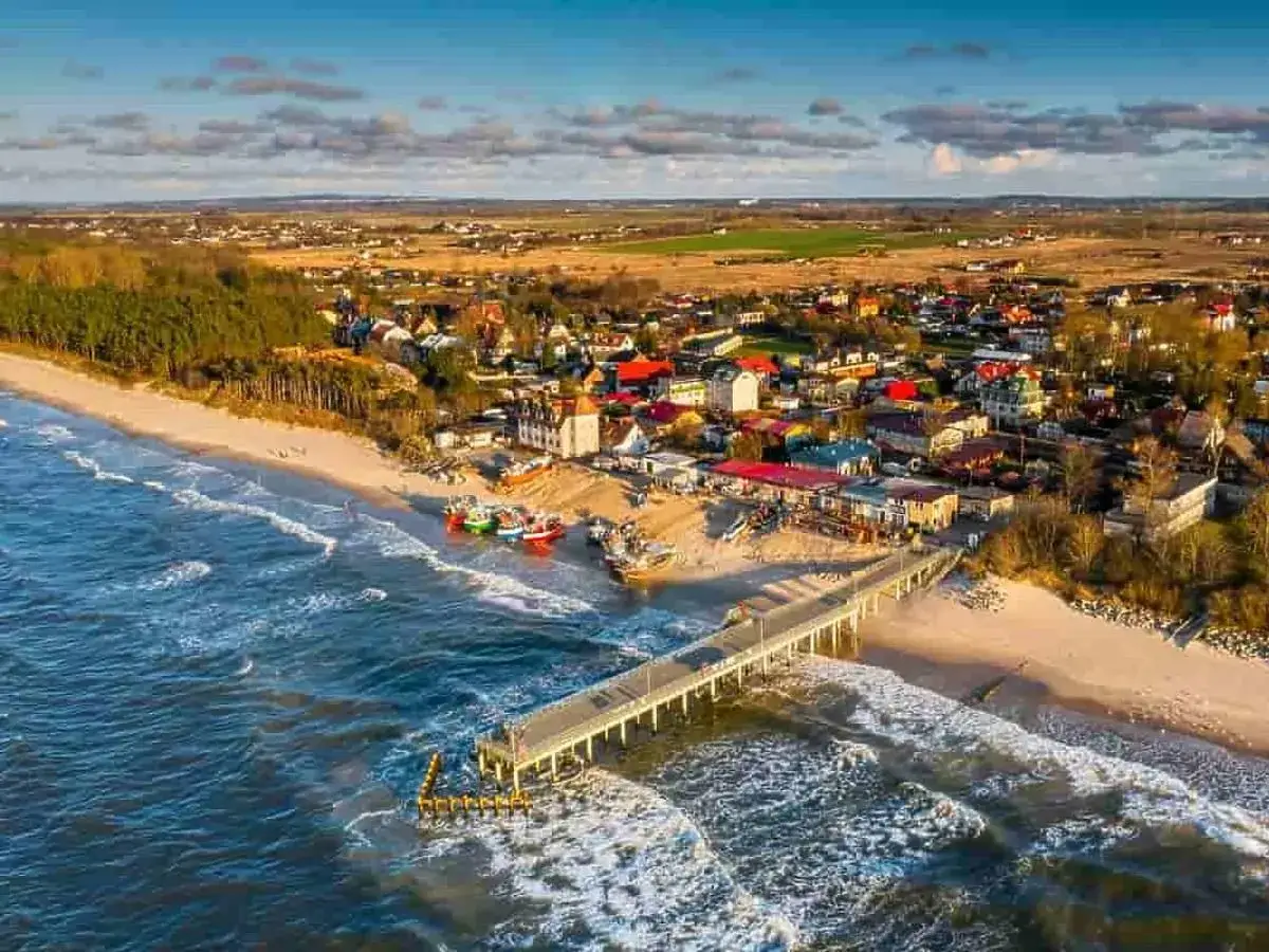 Urocza plaża z molo i kolorowymi łodziami, idealne miejsce, gdzie na wakacje z rocznym dzieckiem.