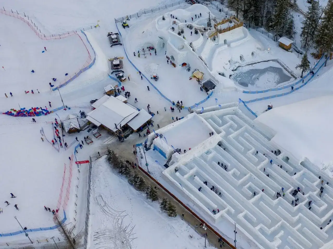 Zimowy labirynt zakopane zaprasza do zabawy. Ludzie przemierzają śnieżne korytarze, szukając wyjścia.